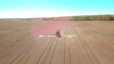Traktör gün batımında tarlaya sprey, ot ilacı ve böcek ilacı püskürtüyor..