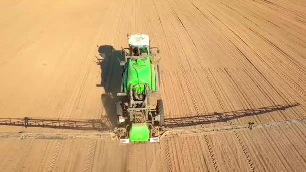 Трактор опрыскивает поле опрыскивателем, гербицидами и пестицидами на закате. — стоковое видео