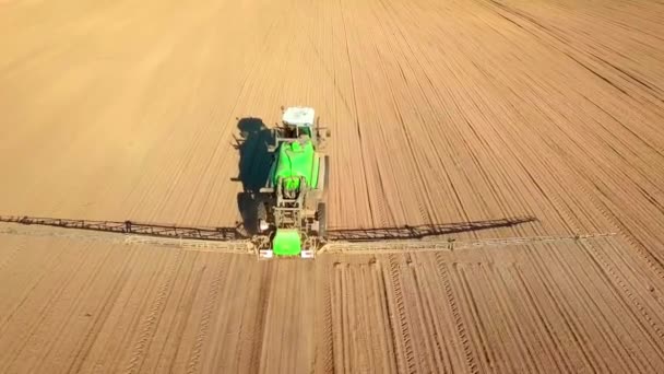 Trator pulverizando um campo com pulverizador, herbicidas e pesticidas ao pôr do sol. — Vídeo de Stock