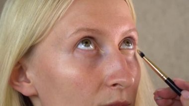 Güzellik salonundaki bir bayan müşteri makyaj yapıyor..