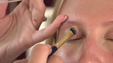 Güzellik salonundaki bir bayan müşteri makyaj yapıyor..