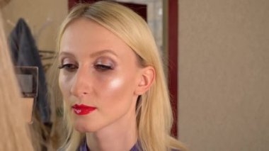 Usta pudra sürüyor, bronzlaştırıcı ve özel fırçayla genç bir model üzerinde.,