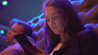 Genç ve güzel bir kadın bir gece kulübünde sıkılıp esniyor..