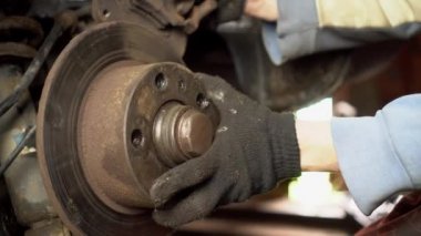 Araba tamircisinin ya da ustanın elleri arabanın frenlerini tamir eder..