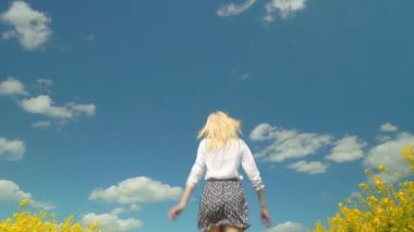 Kadın hızla koşar çiçek açan kolları açık, gülümseyen bir şekilde.