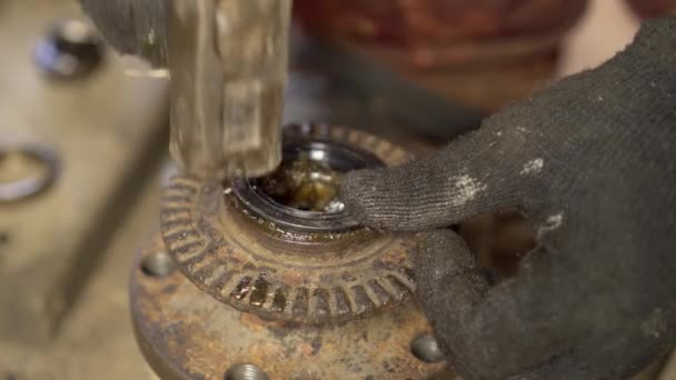 Mästarens händer monterar oljeseglingen och trycker in den i navet. — Stockvideo