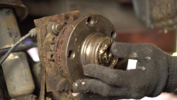 Hands of master or auto mechanic repair and change hub and bearing in car. — Stock Video