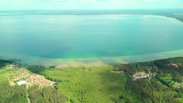 Drone flies over the lake on the background of peninsula and green vegetation. — Stock Video