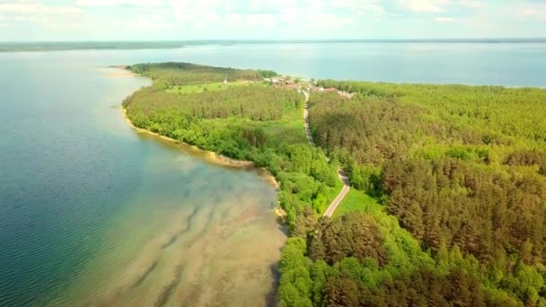 Drönare flyger över sjön på bakgrunden av halvön och grön vegetation. — Stockvideo