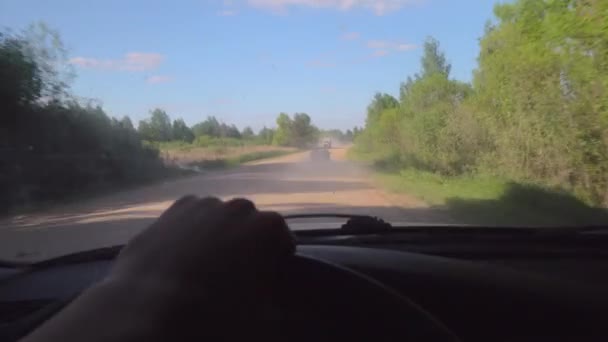 Cars race for speed on dirt gravel road, kicking up dust. camera in first person — Stock Video