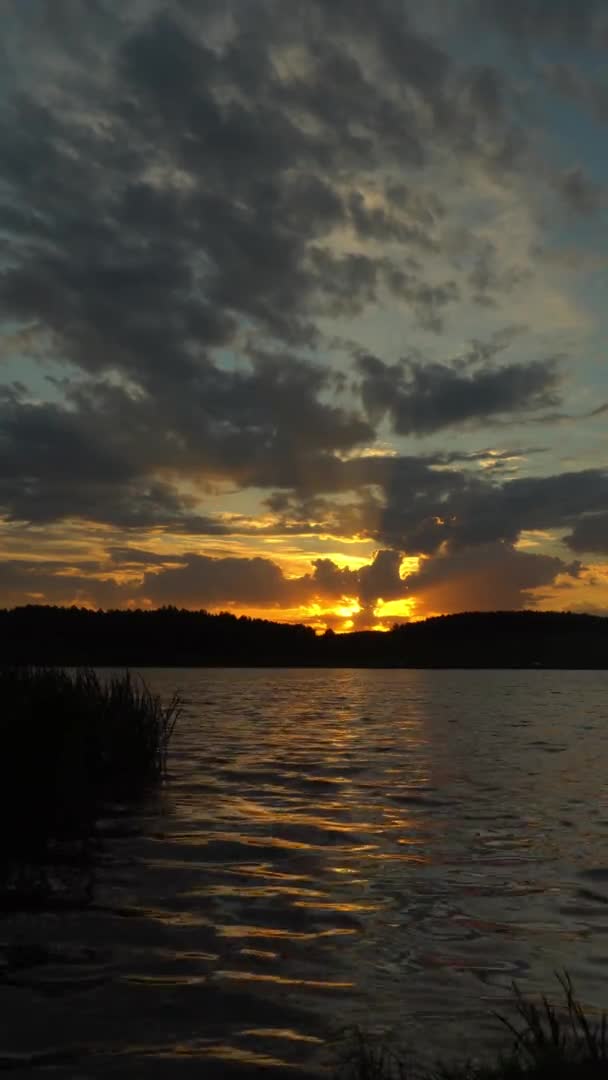 Vista baia contro orizzonte con tramonto e cielo arancione sotto dense nuvole in movimento. — Video Stock