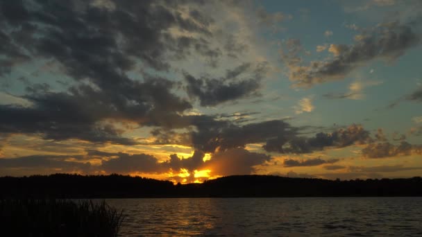 Vista baía contra horizonte com pôr do sol e céu laranja sob densas nuvens em movimento. — Vídeo de Stock