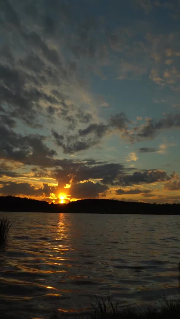 Widok zatoki przed horyzontem z zachodem słońca i pomarańczowe niebo pod gęste chmury ruchome. — Wideo stockowe