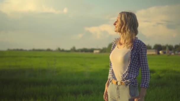 Ung vacker flicka poserar för kameran vid solnedgången på landsbygden. — Stockvideo