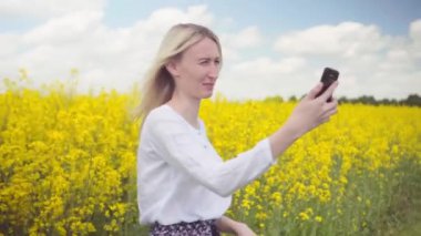 Güzel bir kadın akıllı telefonuyla tecavüz tohumu tarlasında selfie çeker..