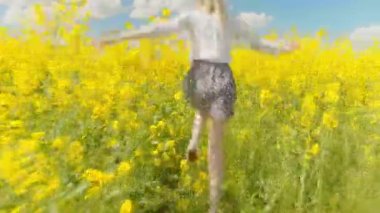 Genç bir kadın çiçek açan bir ırz tohumunun arasında koşuyor..