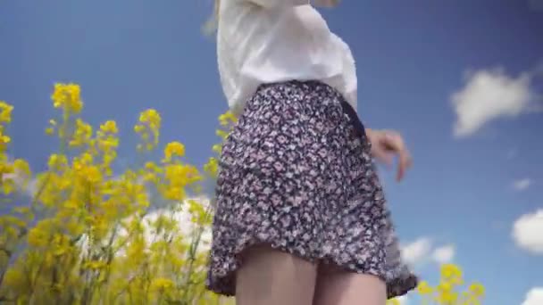 Porträtt av en lycklig kvinna som tar selfie i ett fält av gula rapsfrön blommor. — Stockvideo