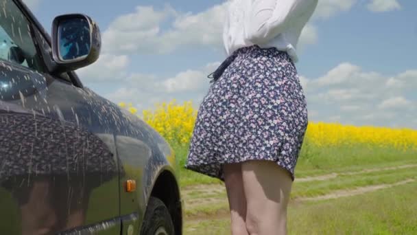 Femme blanche regarde désespérément sa voiture coincée dans la boue dans la campagne dans le village. — Video