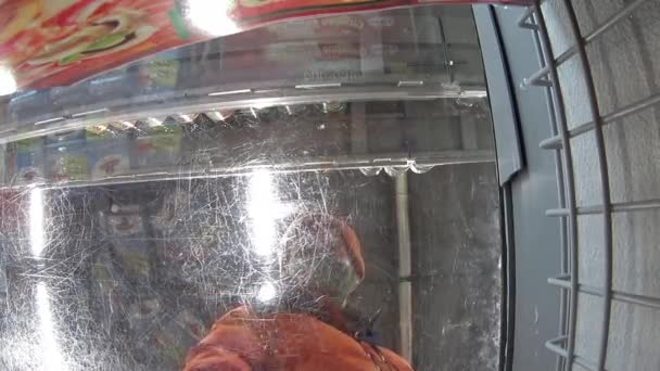 Man opent koelkast en selecteert producten in de winkel. camera is binnen. — Stockvideo