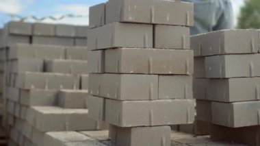 Bir işçi iş yerine tuğla yığını ya da kaldırım döşemesi serer.