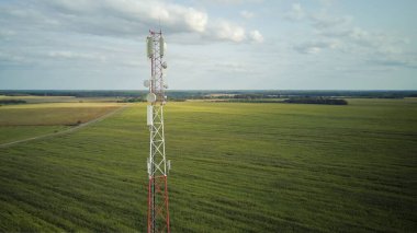 Tarımsal mısır tarlalarının kırsal kesiminde, hücresel ağ antenleri olan bir telekomünikasyon kulesinin insansız hava aracı görüntüsü