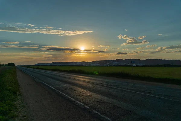 在一条有交叉口的双行道上 从无人驾驶飞机上看到美丽的风景 日落时是一片绿地 — 图库照片