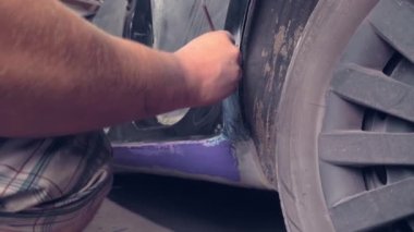 Usta paslanmadan dolayı retro arabayı restore ediyor. Eşikleri onarıyor.