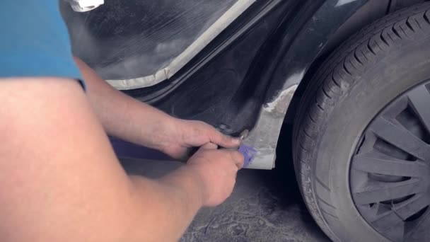 Майстер відновлює ретро-автомобіль від корозії іржі. Він ремонтує пороги — стокове відео