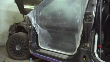Arabanın ve diğer vücut elemanlarının deliklerini boya bandıyla kapatan bir ressam.,