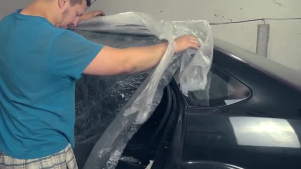 Pintor que sela os furos do carro e outros elementos do corpo com fita adesiva, — Vídeo de Stock