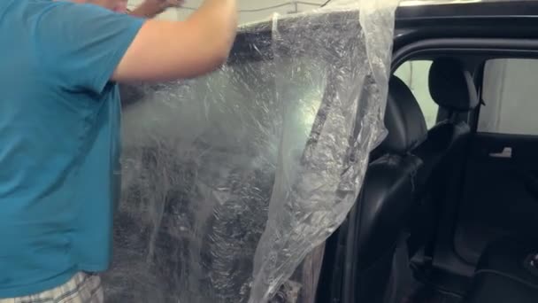Pintor que sela os furos do carro e outros elementos do corpo com fita adesiva, — Vídeo de Stock