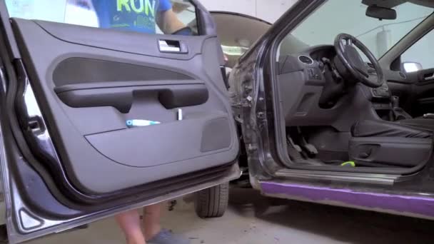 El maestro quita la puerta en el coche para restaurar el coche. — Vídeos de Stock