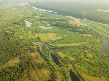 Nehirde bir insansız hava aracıyla güzel bir yaz manzarası. Sel çayırları, tarlalar, ormanlar.