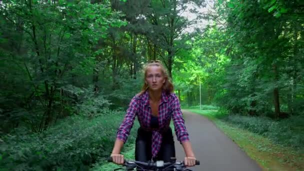 Genç bir kadın ormanda bisiklet sürüyor. Temiz ormanı seviyor. Temiz hava. — Stok video