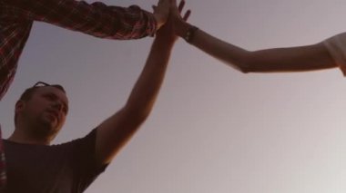 İnsanlar ellerini havaya kaldırıp, birbirlerinin ellerini çırpıyorlar.