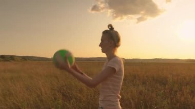 Kadın topun parmağında nasıl döndürüleceğini öğrenmeye çalışıyor.,