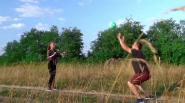 Bir grup genç gün batımında voleybol oynuyor. yavaş çekim,