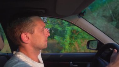 Arabayla seyahat eden genç bir adamın videosu, yol ve kırsal alanlarda eğleniyor.,