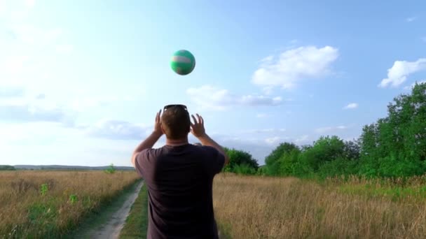 Een groep jongeren volleybal spelen op het veld bij zonsondergang. slow motion, — Stockvideo