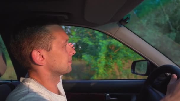 Arabayla seyahat eden genç bir adamın videosu, yol ve kırsal alanlarda eğleniyor., — Stok video