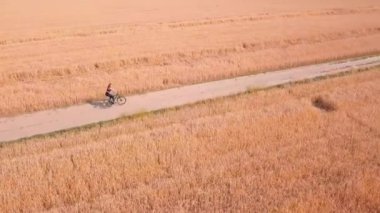 Yaz yolları tarlalardan geçer, kadın sihirli tarlalardan bisikletle geçer.