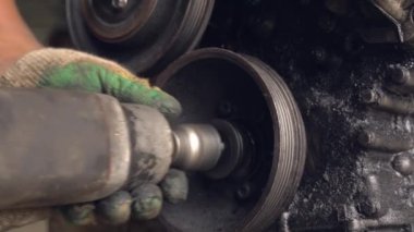 Otomatik tamirci içten yanmalı motoru kontrol eder. Motor petrolle kaplı.