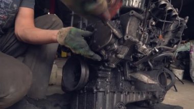 Otomatik tamirci içten yanmalı motoru kontrol eder. Motor petrolle kaplı.