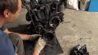 Otomatik tamirci içten yanmalı motoru kontrol eder. Motor petrolle kaplı.