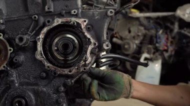 Otomatik tamirci içten yanmalı motoru kontrol eder. Motor petrolle kaplı.