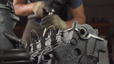 Otomatik tamirci içten yanmalı motoru kontrol eder. Motor petrolle kaplı.