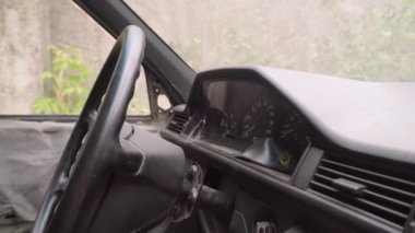 Paslı terk edilmiş araba. Kabinde iç görünüm, panelde örümcek ağları.