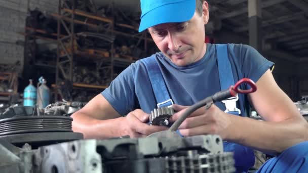 Вид разобранного автомобильного двигателя. руки механического ремонта двигателя — стоковое видео