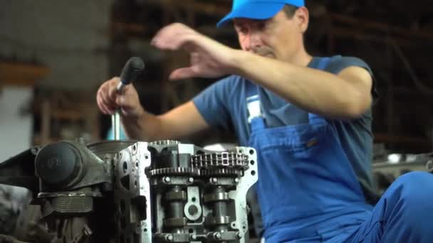 분해 된 자동차 엔진의 모습. 엔진을 수리하는 기술자의 손 — 비디오