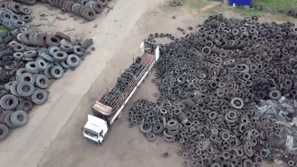 Há muitos pneus descartados para reciclagem de borracha no depósito de rodas. Drone. — Vídeo de Stock